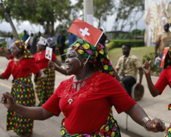 Des danseurs portant des drapeaux suisses accueillent le président suisse Alain Berset lors d'une visite d'État de cinq jours au Botswana et au Mozambique le mois dernier © Keystone / Peter Klaunzer