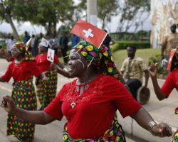 Dancers wearing Swiss flags welcome Swiss President Alain Berset on a five-day state visit to Botswana and Mozambique last month © Keystone / Peter Klaunzer